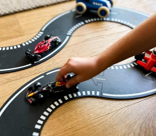 child plays with racing cars on waytoplay rubber road circuit track