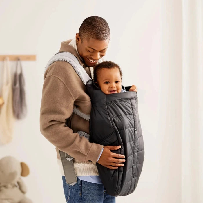 caption-Baby in forward facing Baby Bjorn carrier with winter cover