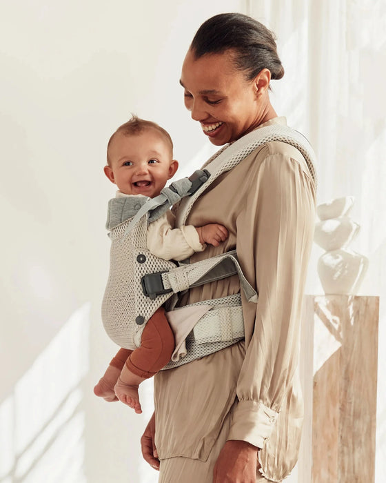 caption-Mother wearing Baby Bjorn Harmony Carrier with baby facing her