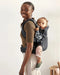 caption-Mother wearing Baby Bjorn Harmony with child in back carry position