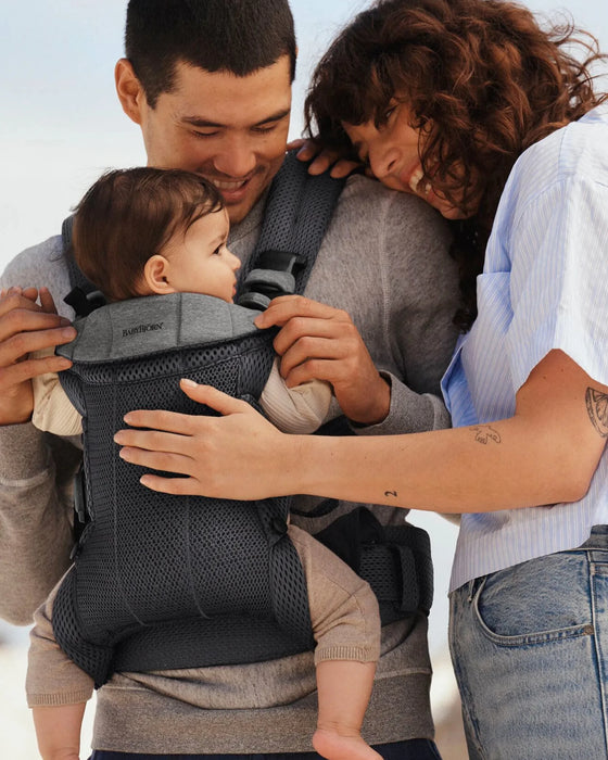 caption-Family spends time outdoors wearing baby in Bjorn Harmony Baby Carrier